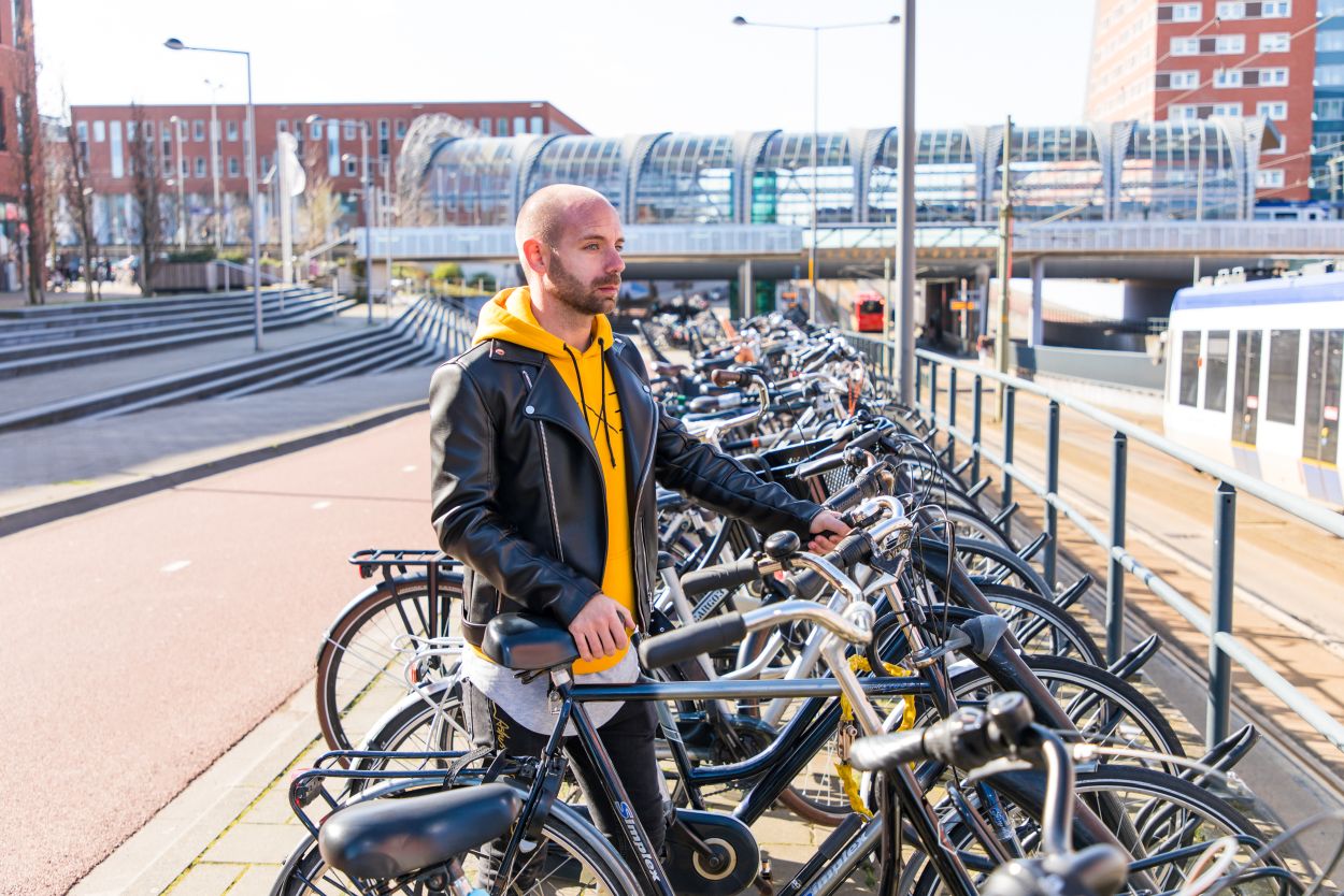Man parkeert fiets in stalling bij RandstadRail halte