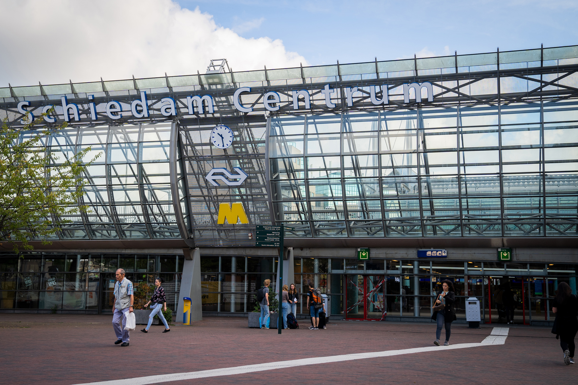 Voetgangers lopen bij de ingang van station Schiedam Centrum