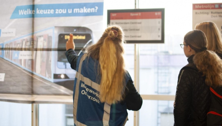 reizigers bij bord dat drukte in metro aangeeft