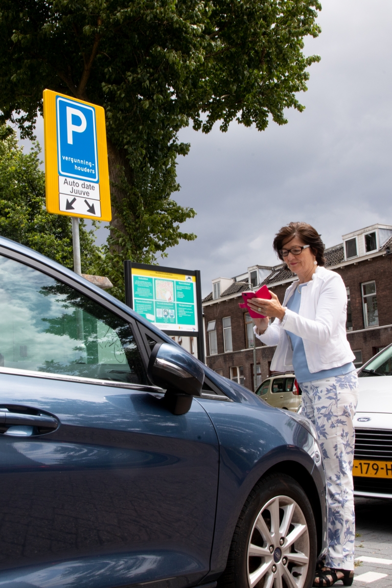 Dame checkt in bij deelauto in Schiedam Deelmobiliteitshub