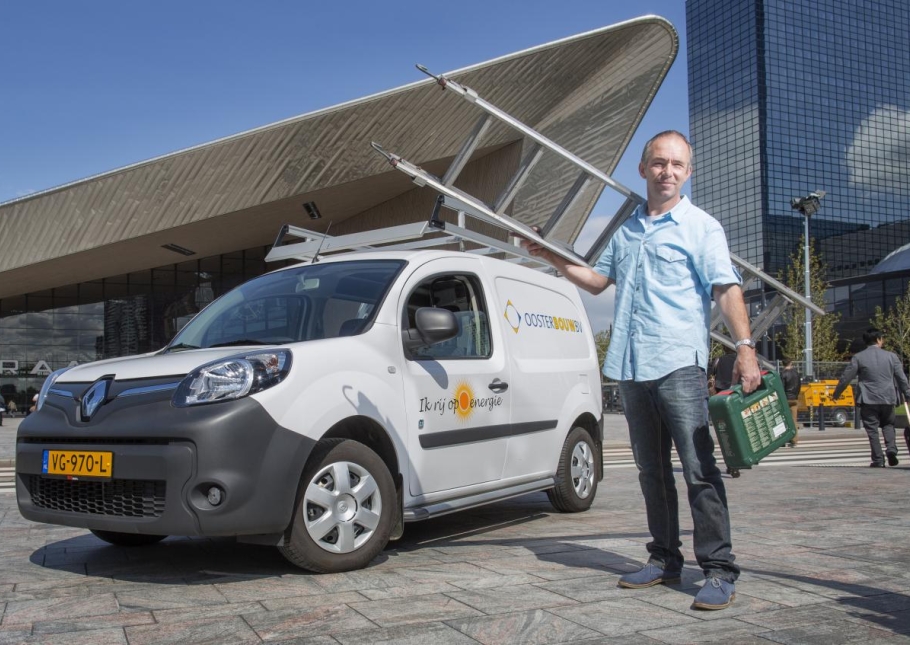 Een man met ladder en koffer staat voor zijn uitstootvrije bestelbus op het plein voor Rotterdam Centraal Station.