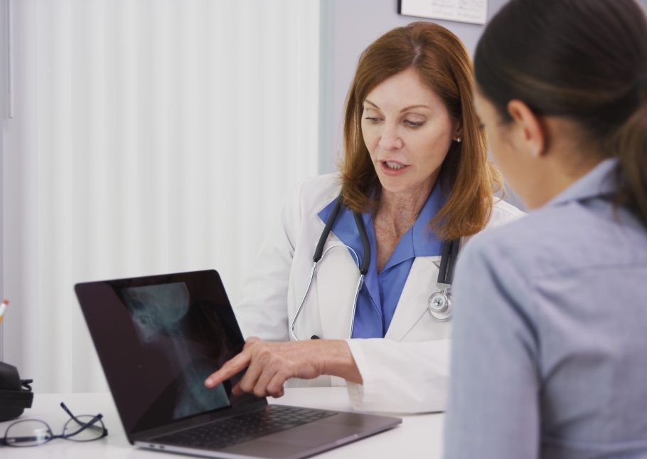 Arts kijkt met patient naar rontgenfoto op de laptop