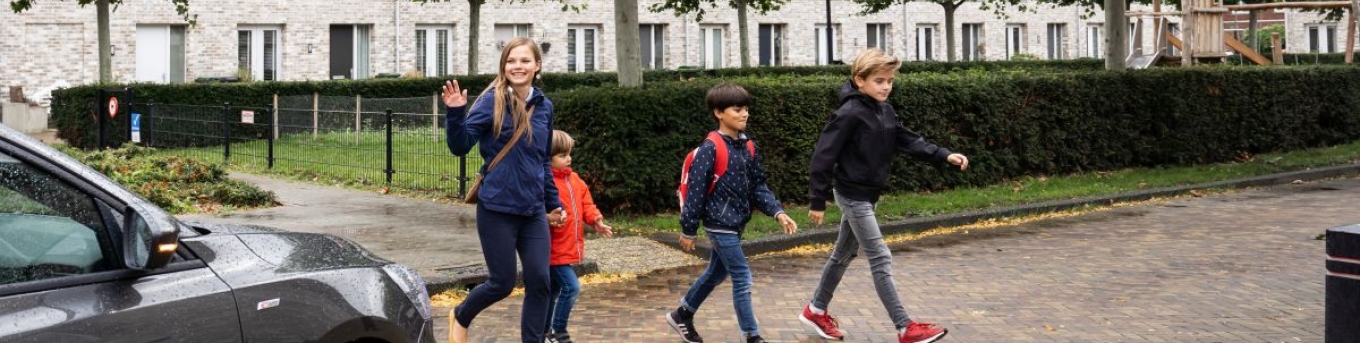 Kinderen steken over in een woonwijk. De automobilist stopt.