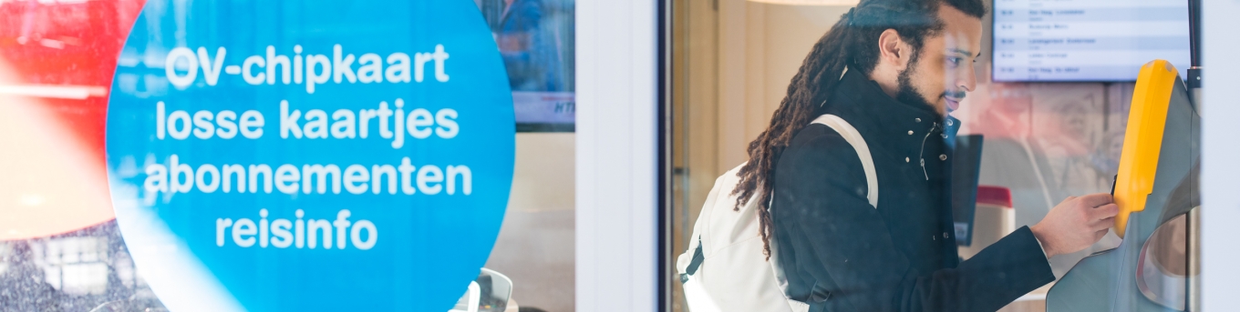 Man checkt in bij automaat ov-chipkaart
