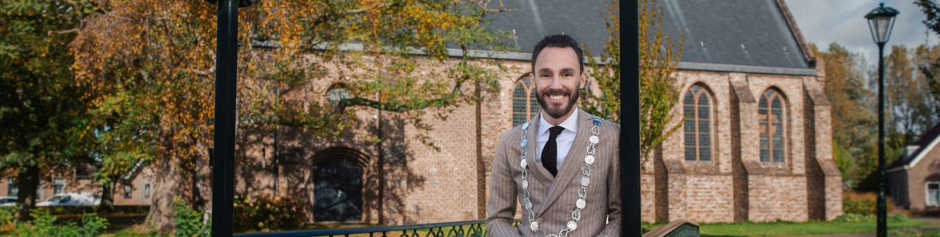 Burgemeester Arno Schepers staat op de Davidsbrug voor een kerk