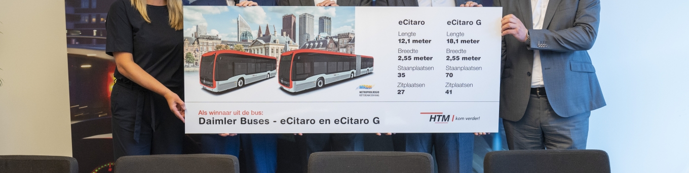 Karen Bosch (HTM), Jeffrey Keus (portefeuillehouder OV MRDH), Rien Heilbron (HTM), Joost van der Bijl en Dirk Meppelink (Daimler Buses NL) tonen een bord met afbeelding van de nieuwe elektrische bussen van HTM