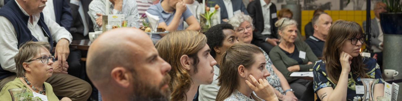 mensen in zaal luisterend naar spreker