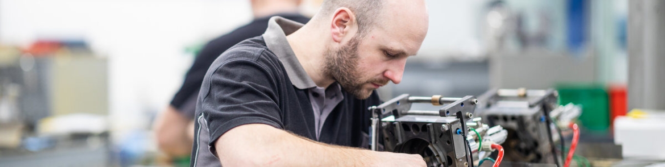 Man sleutelt aan een apparaat in een werkplaats - Foto: MICS/FMI
