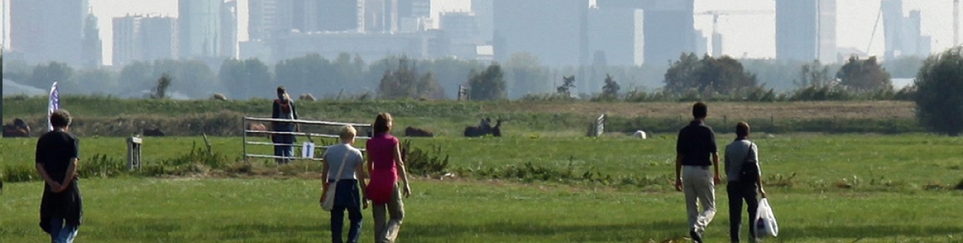 Fotograaf: Henk Groenendaal, Mensen wandelen door de weilanden. Op de achtergrond skyline van Rotterdam.