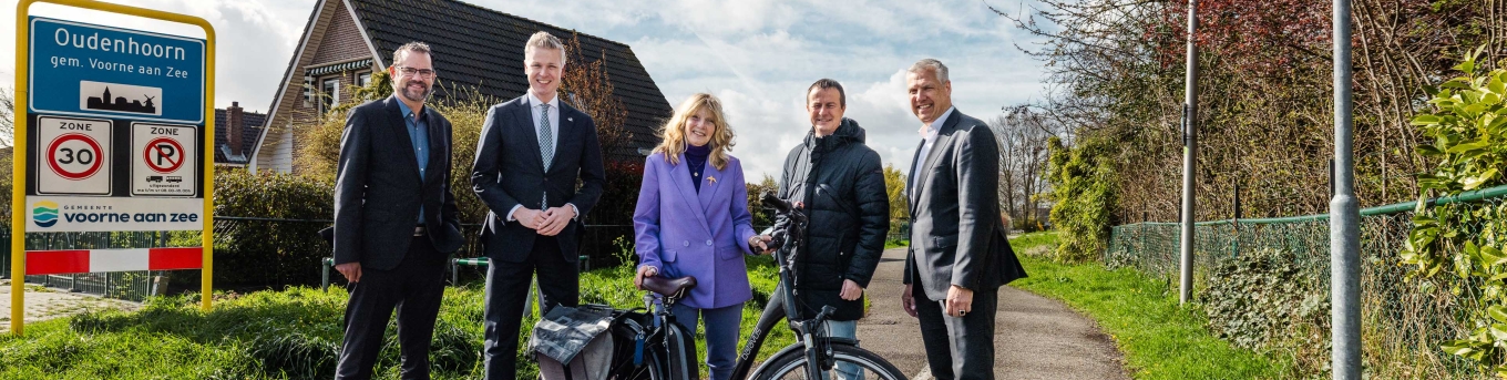 Bestuurders van Voorne aan Zee, provincie Zuid-Holland, waterschap, Nissewaard en Metropoolregio staan op het Trambaanpad.