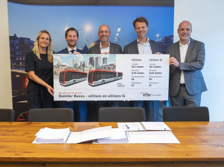Karen Bosch (HTM), Jeffrey Keus (portefeuillehouder OV MRDH), Rien Heilbron (HTM), Joost van der Bijl en Dirk Meppelink (Daimler Buses NL) tonen een bord met afbeelding van de nieuwe elektrische bussen van HTM