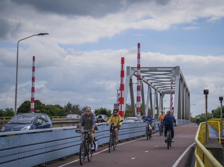 Fietsers en auto's rijden over de Algerabrug
