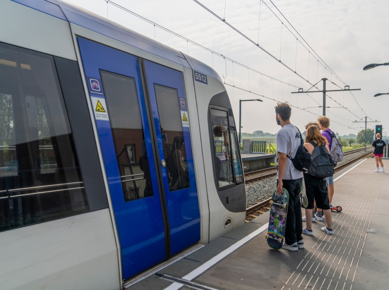 Jonge reizigers op halte bij de metro
