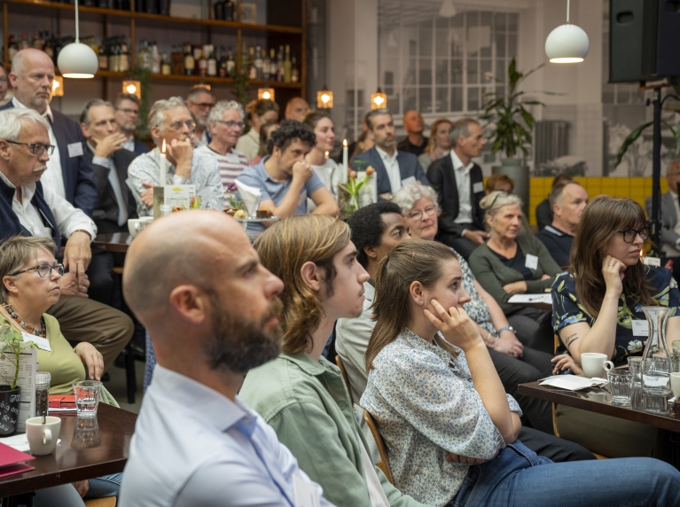 mensen in zaal luisterend naar spreker