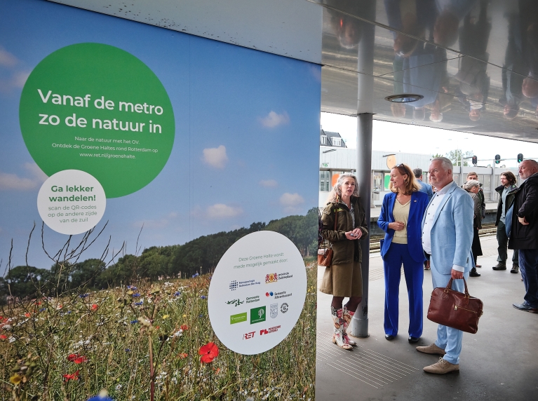 Genodigden kijken naar de informatiepanelen op metrohalte Rhoon