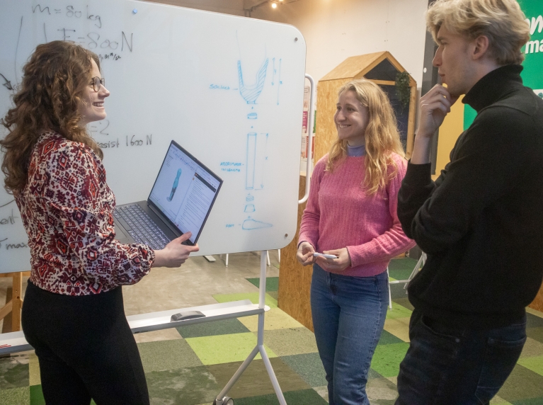 studenten voor bord met schets van prothese
