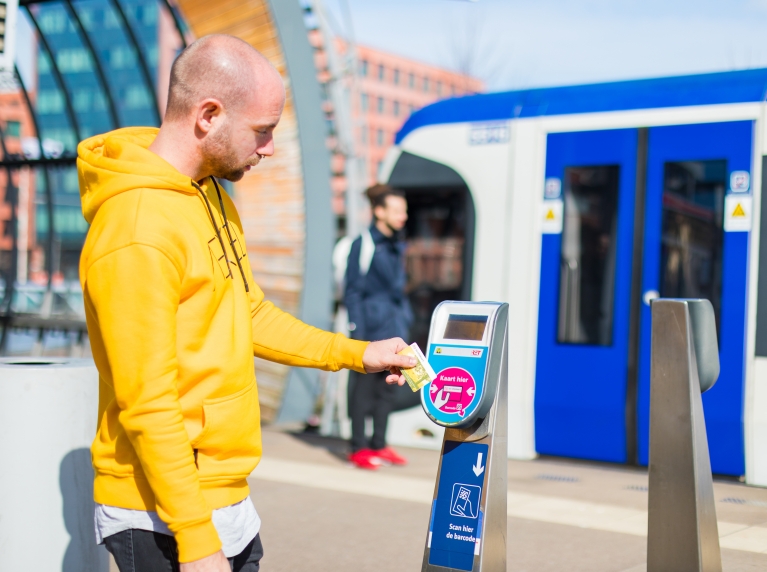 Reiziger checkt in bij RET metro met chipkaart