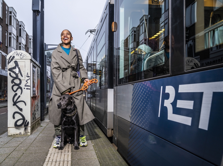 Vrouw met hond op RET tramhalte