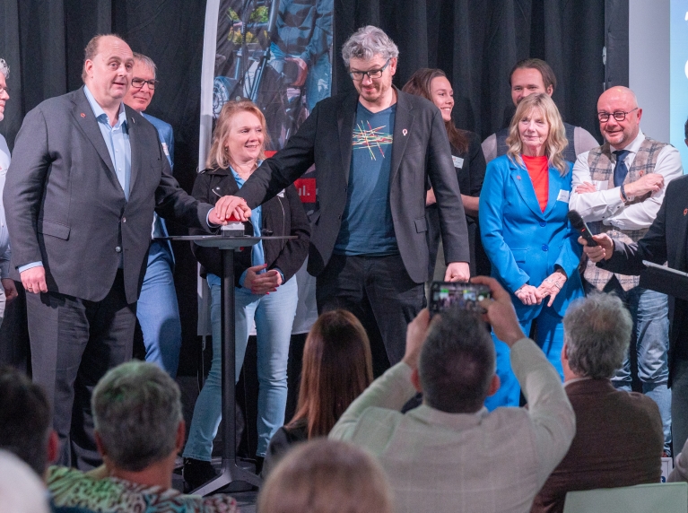 Frederik Zevenbergen en Arjen Kapteijns drukken samen op een rode knop om de verkeersveiligheidscampagne #impact te lanceren