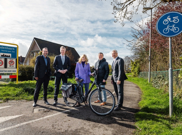 Bestuurders van Voorne aan Zee, provincie Zuid-Holland, waterschap, Nissewaard en Metropoolregio staan op het Trambaanpad. 