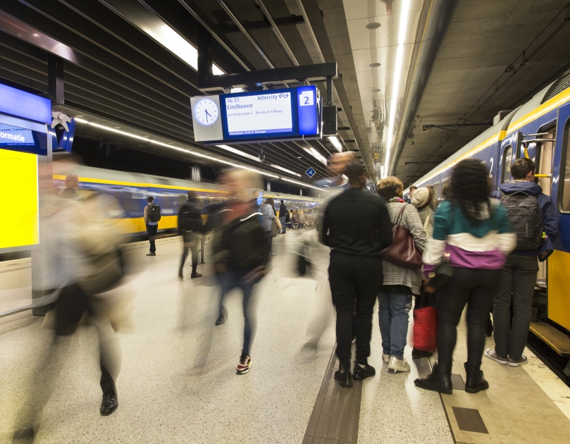 Reizigers op station Delft stappen in en uit de trein